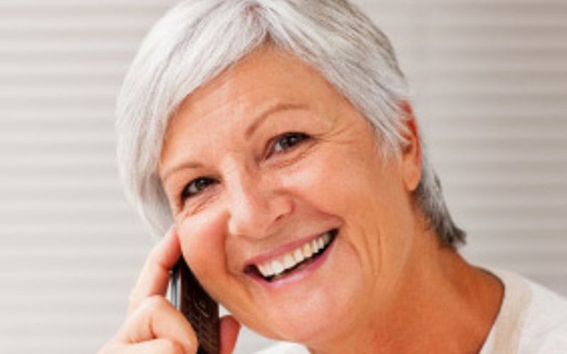 Ältere Frau lacht während einem Telefonat