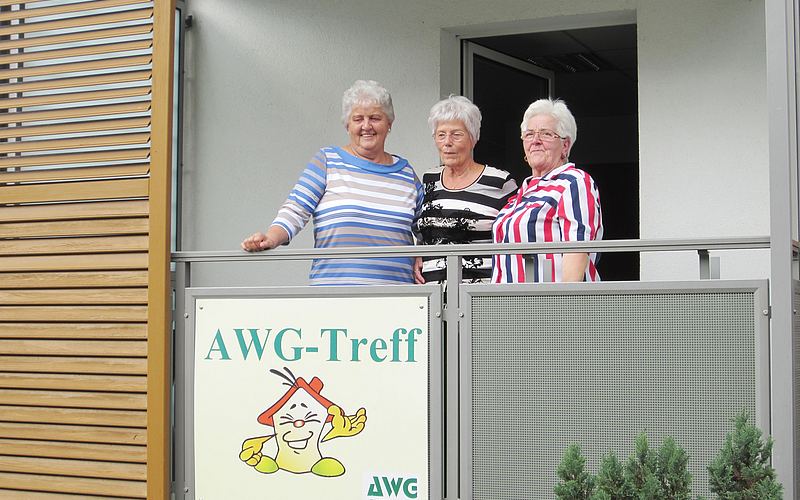 3 ältere Frauen schauen von einem Balkon
